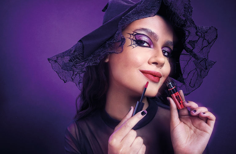 Mujer con un maquillaje de Halloween de bruja con un labial rojo Faces en las manos